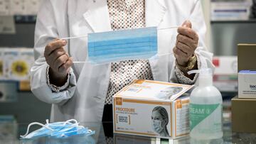 Una farmacéutica sostiene una mascarilla.