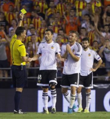 El defensa alemán del Valencia CF Shkodran Mustafi recibe tarjeta amarilla del árbitro inglés Mark Clattenburg.