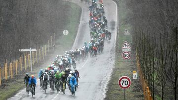 The pack rides in a heavy rain as they take the start of the 148,5km first stage of the 75th edition of the Paris-Nice cycling race, in and around Bois d&#039;Arcy, near Paris on March 5, 2017. / AFP PHOTO / Philippe LOPEZ