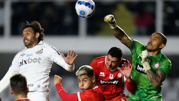 Chile's Union La Calera goalkeeper Argentine Ignacio Arce (R) and Brazil's Santos Ricardo Goulart (L) vie for the ball during their Copa Sudamericana group stage football match, at the Urbano Caldeira stadium in Santos, Brazil, on May 18, 2022. (Photo by Paulo Pinto / AFP)