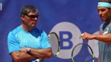 Toni Nadal escucha a su sobrino Rafael Nadal acerca de una posición en la pista.