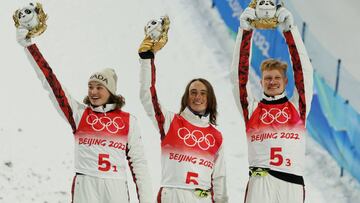 Bronze medallists Marion Thenault of Canada, Miha Fontaine of Canada and Lewis Irving of Canada celebrate holding the awards depicting Bing Dwen Dwen, the mascot of the Beijing 2022 Winter Olympics, on the podium. 