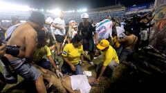 Rescuers attend an injured man lying on the pitch following a stampede during a football match between Alianza and FAS at Cuscatlan stadium in San Salvador, on May 20, 2023. Nine people were killed May 20, 2023 in a stampede at an El Salvador stadium where soccer fans had gathered to watch a local tournament, police said. (Photo by Milton FLORES / AFP)