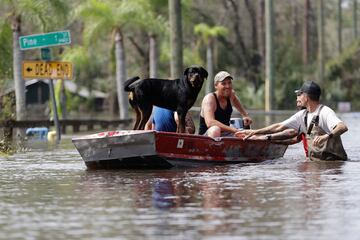 Los residentes viajan en un bote en un vecindario inundado por la histórica inundación del río Alafia causada por el huracán Milton.