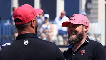 WESTFIELD, INDIANA - AUGUST 17: Jon Rahm of Legion XIII speaks with teammate Tyrell Hatton on the 18th green on day three of LIV Golf Indianapolis at The Club at Chatham Hills on August 17, 2025 in Westfield, Indiana. Justin Casterline/Getty Images/AFP (Photo by Justin Casterline / GETTY IMAGES NORTH AMERICA / Getty Images via AFP)