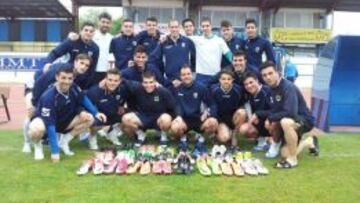 Los jugadores del Parla posan con las botas que les han enviado sus compañeros del Castilla.