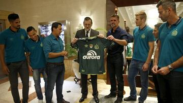 Fotografía facilitada por la Presidencia del Gobierno del presidente Mariano Rajoy recibiendo una camiseta firmada del equipo brasileño de fútbol de Chapecoense, con cuyos integrantes coincidió en el hotel en el que se aloja en Montevideo durante su visita oficial a Uruguay.