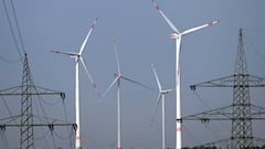 29 August 2022, North Rhine-Westphalia, Neurath: Wind turbines for power generation stand behind electricity pylons. Consumers and businesses in Germany are worried about sharp increases in energy prices. Photo: Federico Gambarini/dpa (Photo by Federico Gambarini/picture alliance via Getty Images)