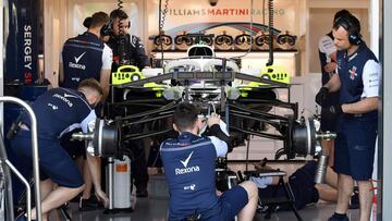 Mechanics work on the car of Williams' Russian driver Sergey Sirotkin in the pits at the Albert Park circuit in Melbourne on March 22, 2018, ahead of the Formula One Australian Grand Prix. / AFP PHOTO / William WEST / -- IMAGE RESTRICTED TO EDITORIAL