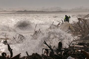 Un voluntario camina mientras busca víctimas de las inundaciones en las orillas del mar Mediterráneo en la playa del Saler, Valencia. 