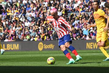 Griezmann durante una jugada del partido se lleva el balón ante la mirada de Sergio Busquets.