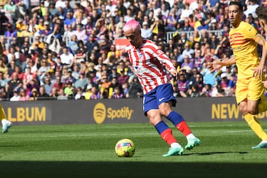 Griezmann durante una jugada del partido se lleva el balón ante la mirada de Sergio Busquets.