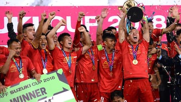 Vietnam's players hold the trophy as they celebrate after winning the AFF Suzuki Cup 2018 final football match between Vietnam and Malaysia at the My Dinh Stadium in Hanoi on December 15, 2018. (Photo by Nhac NGUYEN / AFP)