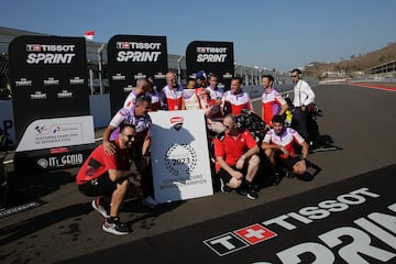 Los miembros del equipo Prima Pramac Racing sostienen una pàncarta confirmando el título de Ducati como campeón del mundial de constructores.