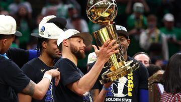 Stephen Curry y demás jugadores de los Golden State Warriors alzan el trofeo Larry O'Brien.