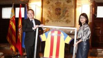 La presidenta del Valencia, Layhoon Chan, le entrega una camiseta del Valencia con su nombre y los colores de la senyera al presidente de la Generalitat Valenciana, Ximo Puig
