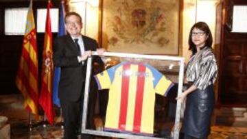 La presidenta del Valencia, Layhoon Chan, le entrega una camiseta del Valencia con su nombre y los colores de la senyera al presidente de la Generalitat Valenciana, Ximo Puig