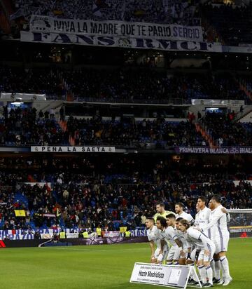 The Real Madrid players line up for their pre-match photo, with the supporters' banner above them.