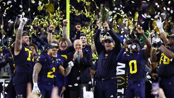 HOUSTON, TEXAS - JANUARY 08: Head coach Jim Harbaugh of the Michigan Wolverines and his team react as he lifts the national championship trophy after defeating the Washington Huskies during the 2024 CFP National Championship game at NRG Stadium on January 08, 2024 in Houston, Texas. Michigan defeated Washington 34-13. Maddie Meyer/Getty Images/AFP (Photo by Maddie Meyer / GETTY IMAGES NORTH AMERICA / Getty Images via AFP)