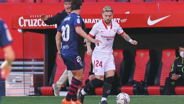 13 February 2021, Spain, Sevilla: Sevilla's Papu Gomez (R) and Huesca's Jaime Seoane battle for the ball during Spanish Primera Division soccer match between Sevilla FC and SD Huesca at Ramon Sanchez-Pizjuan Stadium. Photo: Jose Luis Contreras/