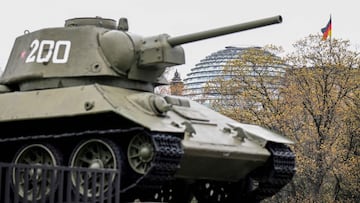 A T-34 Soviet tank as part of The Soviet War Memorial dedicated to the fallen soldiers in WWII is pictured backdropped by the Cupola of the Reichstag building that houses the Bundestag (lower house of Parliament) in Berlinx91s Tiergarten district on April 21, 2022. (Photo by Tobias SCHWARZ / AFP)