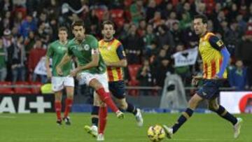 Xabi Prieto golpea el bal&oacute;n ante la presencia de Busquets.