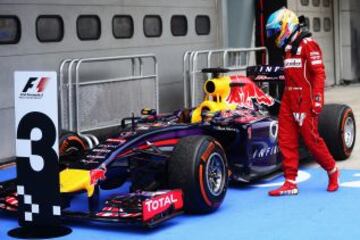 Fernando Alonso mira el coche de Sebastian Vettel de Alemania en el parque cerrado después del GP de Malaisia