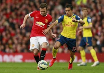 Alexis Sánchez lucha la pelota con Juan Mata.