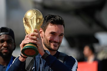 France's goalkeeper Hugo Lloris smiles as he holds the trophy as he celebrates with teammates upon their arrival at the Roissy-Charles de Gaulle airport on the outskirts of Paris, on July 16, 2018 after winning the Russia 2018 World Cup final football mat