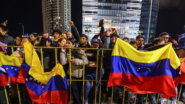 Personas sosteniendo la bandera de Venezuela, unos de los países con prohibiciones parciales de entrada a Estados Unidos.