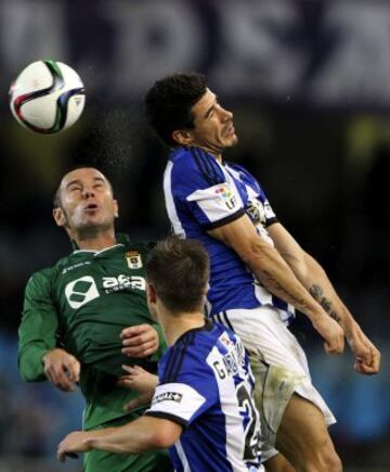 El centrocampista de la Real Sociedad, Pablo Hervías (d), salta por el balón con Diego Cervero (i), del Oviedo, durante el partido de vuelta de dieciseisavos de final de la Copa del Rey que se disputa esta noche en el estadio de Anoeta, en San Sebastián.