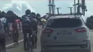 Alexandre Geniez y Nico Denz se agarran al coche del AG2R durante una subida en la etapa de Sierra Nevada en la Vuelta a Espa&ntilde;a.