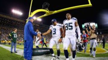 Russell Wilson y Shead, jugadores de los Seahawks, se marchan de Lambeau Field tras perder ante los Packers.