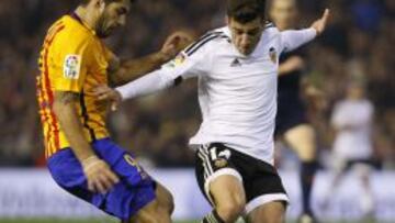 Gay&aacute; pelea un bal&oacute;n con Luis Su&aacute;rez durante el partido de Liga BBVA entre Valencia y F.C. Barcelona en Mestalla.
