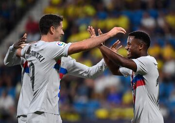 El centrocampista español del Barcelona Ansu Fati celebra con el delantero polaco del Barcelona Robert Lewandowski después de marcar el tercer gol de su equipo.