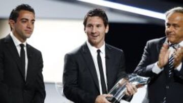 Platini aplaude a Messi con Xavi a la derecha del argentino.