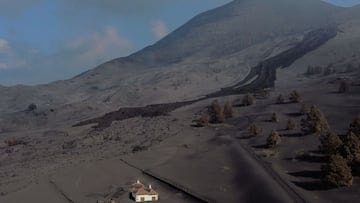 This aerial picture shows a house covered with lava and ashes following the eruption of the Cumbre Vieja volcano, in Las Manchas, on the Canary Island of La Palma on December 14, 2021. - The Cumbre Vieja volcano has been erupting since September 19, forci