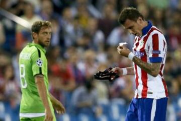 El delantero croata del Atlético de Madrid Mario Mandzukic (d) se quita el protector nasal durante el partido de la segunda jornada de la fase de grupos de la Liga de Campeones que Atlético de Madrid y Juventus disputan esta noche en el estadio Vicente Calderón, en Madrid. 