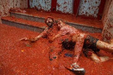 BUNOL, SPAIN - AUGUST 30: Revellers enjoy the atmosphere in tomato pulp while participating the annual Tomatina festival on August 30, 2017 in Bunol, Spain. An estimated 22,000 people threw 150 tons of ripe tomatoes in the world's biggest tomato fight held annually in this Spanish Mediterranean town. (Photo by Pablo Blazquez Dominguez/Getty Images)