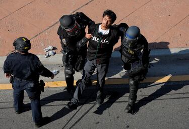 La policía detiene a un manifestante durante una protesta contra las redadas federales de inmigración en el centro de Los Ángeles.