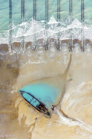 Un naufragio de la primera guerra mundial asoma en una playa de la costa francesa, donde le golpean las olas.