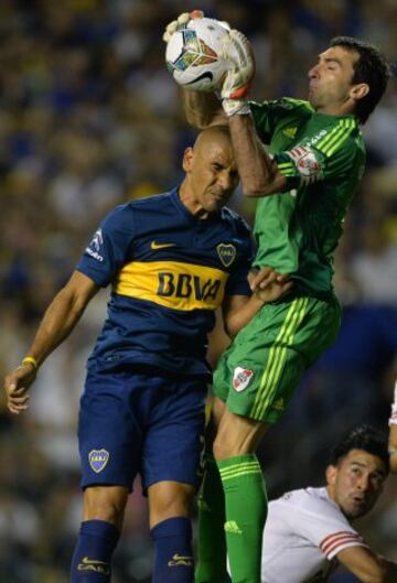 BAS101. BUENOS AIRES (ARGENTINA) 20/11/2014 .- Daniel Diaz(i) de Boca Junior salta a disputar un balón con Marcelo Barovero (d) de River Plate durante el partido por la semifinal de la Copa Sudamericana hoy, jueves 20 de noviembre de 2014, en la Bombonera de Buenos Aires (Argentina). EFE/Juan Ignacio Roncoroni