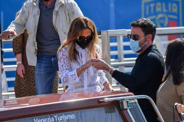 US actor Ben Affleck (R) helps US actress and singer Jennifer Lopez as they board a vaporetto taxi boat on September 9, 2021 after they arrived to attend the 78th Venice Film Festival in Venice. (Photo by Filippo MONTEFORTE / AFP)