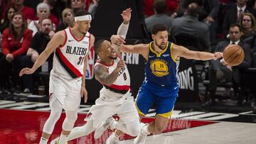 Damian Lillard trata de robar el balón a Klay Thompson.