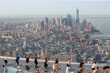 Un grupo de personas hace yoga en la azotea de un edificio de Manhattan (Nueva York). Como ocurre con muchos tipos de ejercicios al aire libre, esta práctica cogió gran demanda durante la pandemia del coronavirus, y no se ha pasado de moda, sino más bien al contrario: hay semanas de lista de espera para asistir a las clases.