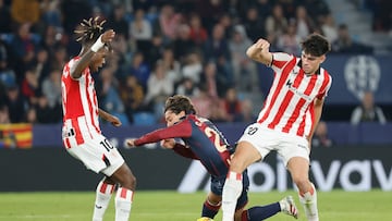 VALENCIA, 29/11/2025.- El centrocampista del Levante Carlos Álvarez (c) pelea un balón con Nico Williams (i) y Alejandro Rego, ambos del Athletic, durante el partido de LaLiga que Levante UD y Athletic Club disputan este sábado en el estadio Ciutat de Valencia. EFE/Ana Escobar