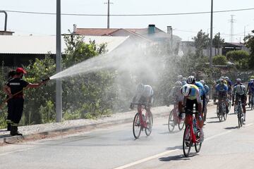 Las altas temperaturas que registró la Penísula Ibérica a mediados de agosto, afectada por una ola de calor, propiciaron imágenes como esta, en la que se ve cómo los bomberos echaban agua con sus mangueras al pelotón durante la séptima etapa de la Vuelta a Portugal, 193,2 kilómetros entre Felgueiras y Bragança. Los ciclistas seguro que lo agradecieron. 