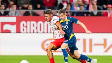 GIRONA, 26/09/2025.- El centrocampista del Espanyol, Pol Lozano (d), disputa el balón ante el defensa del Girona, Hugo Rincón, durante el encuentro correspondiente a la jornada siete de Laliga EA Sports que disputan hoy viernes Girona y Espanyol en el estadio municipal de Montilivi, en Girona. EFE/David Borrat.