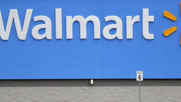 ARCHIVO - En esta fotografía de archivo del 31 de marzo de 2020, una mujer saca alimentos de un carrito a su vehículo afuera de una tienda Walmart en Pearl, Mississippi.