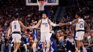 Luka Doncic, base de Dallas Mavericks, choca las manos con sus compañeros Josh Green y P.J. Washington.